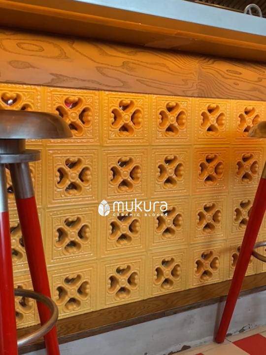 Close up view of the island table featuring ceramic granite blocks Oriental in the color Yellow, with a classic Indonesian motif perfect to decorate this Peranakan cuisine restaurant